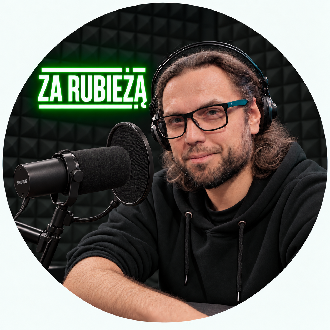 Miłosz Szymański przy mikrofonie, na tle neonu Za Rubieżą